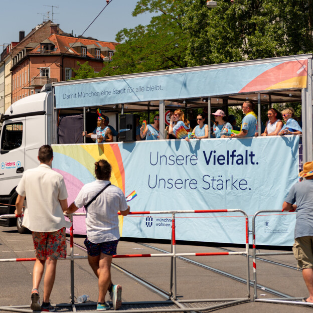 Blick auf den bunt geschmückten Truck der Münchner Wohnen auf dem steht "Unsere Vielfalt. Unsere Stärke.".