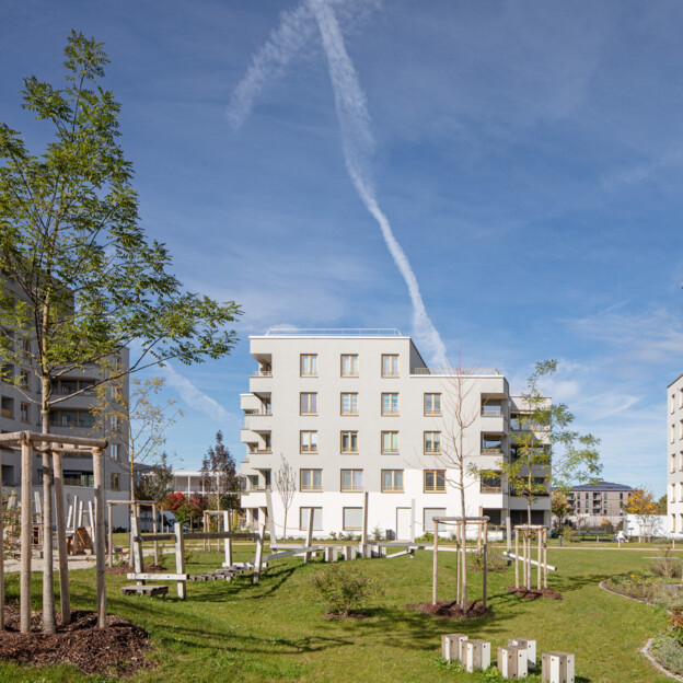 Blick auf die Grünanlage zwischen modernen Neubauten der Münchner Wohnen in Freiham.