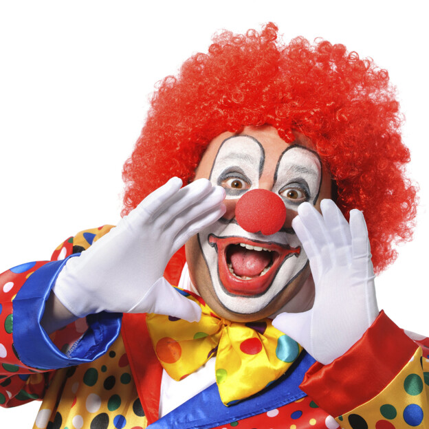 Clown mit roter Perücke und buntem Kostüm