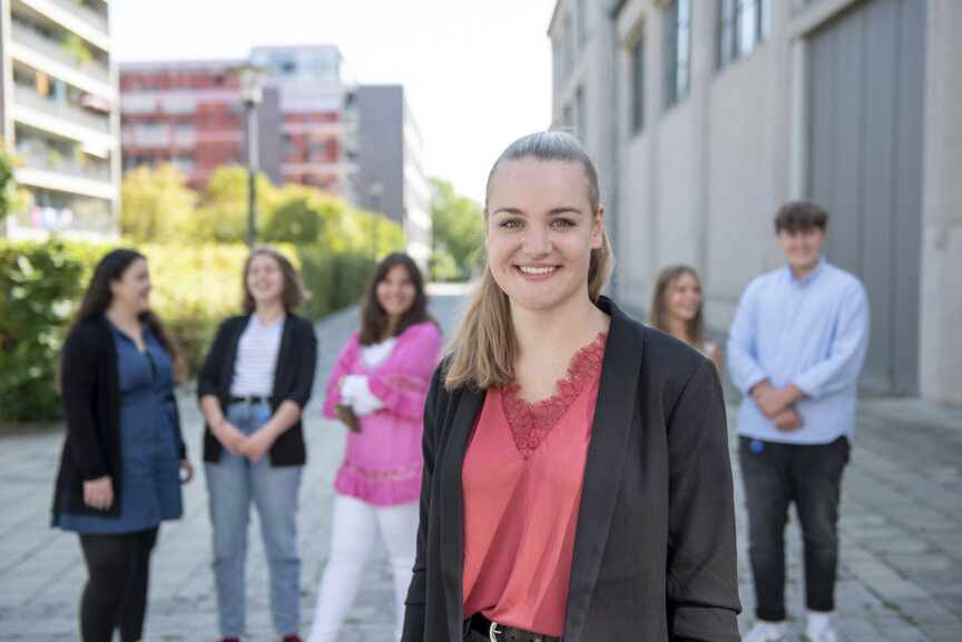 Eine Gruppe junger Menschen vor einem Bürogebäude.