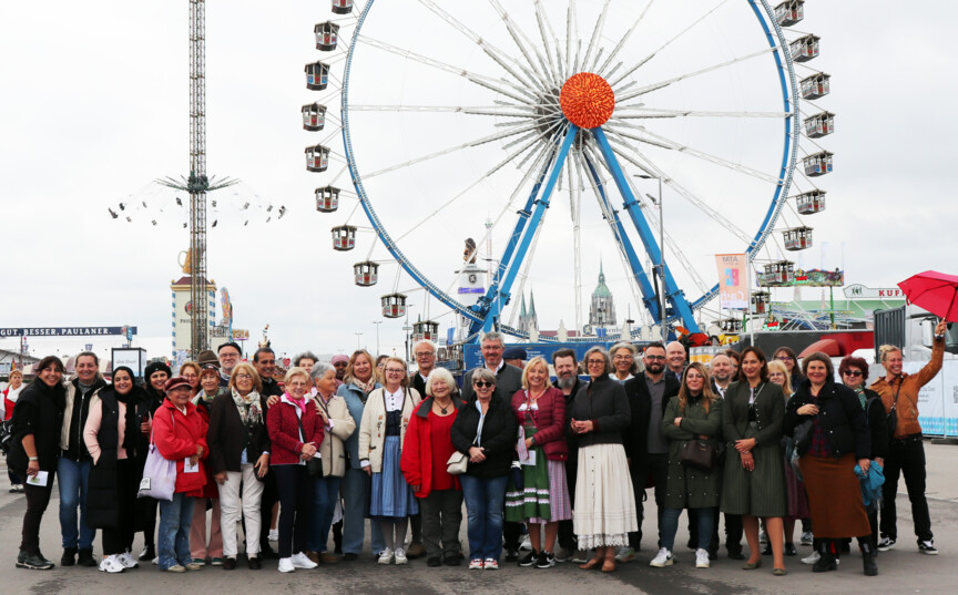 Gruppenbild der Ehrenamtlichen vor dem Riesenrad auf dem Oktoberfest.