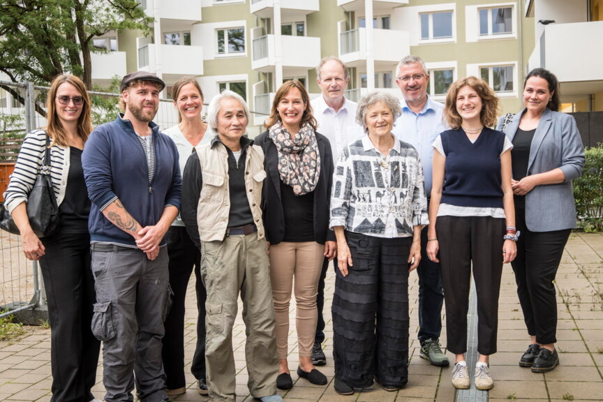 Gruppenbild der Mitarbeiter*innen des Nachbarschaftstreffs, der Geschäftsführung der Münchner Wohnen und der Mitarbeiter*innen der Münchner Wohnen aus den sozialen Diensten.