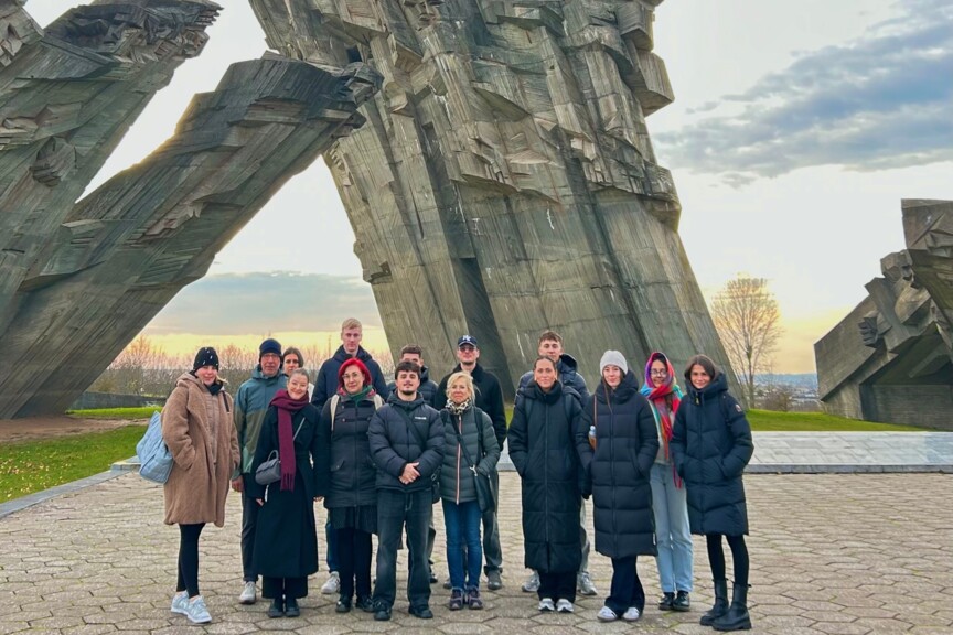 Gruppenbild der Auszubildenden vor einem Mahnmal.