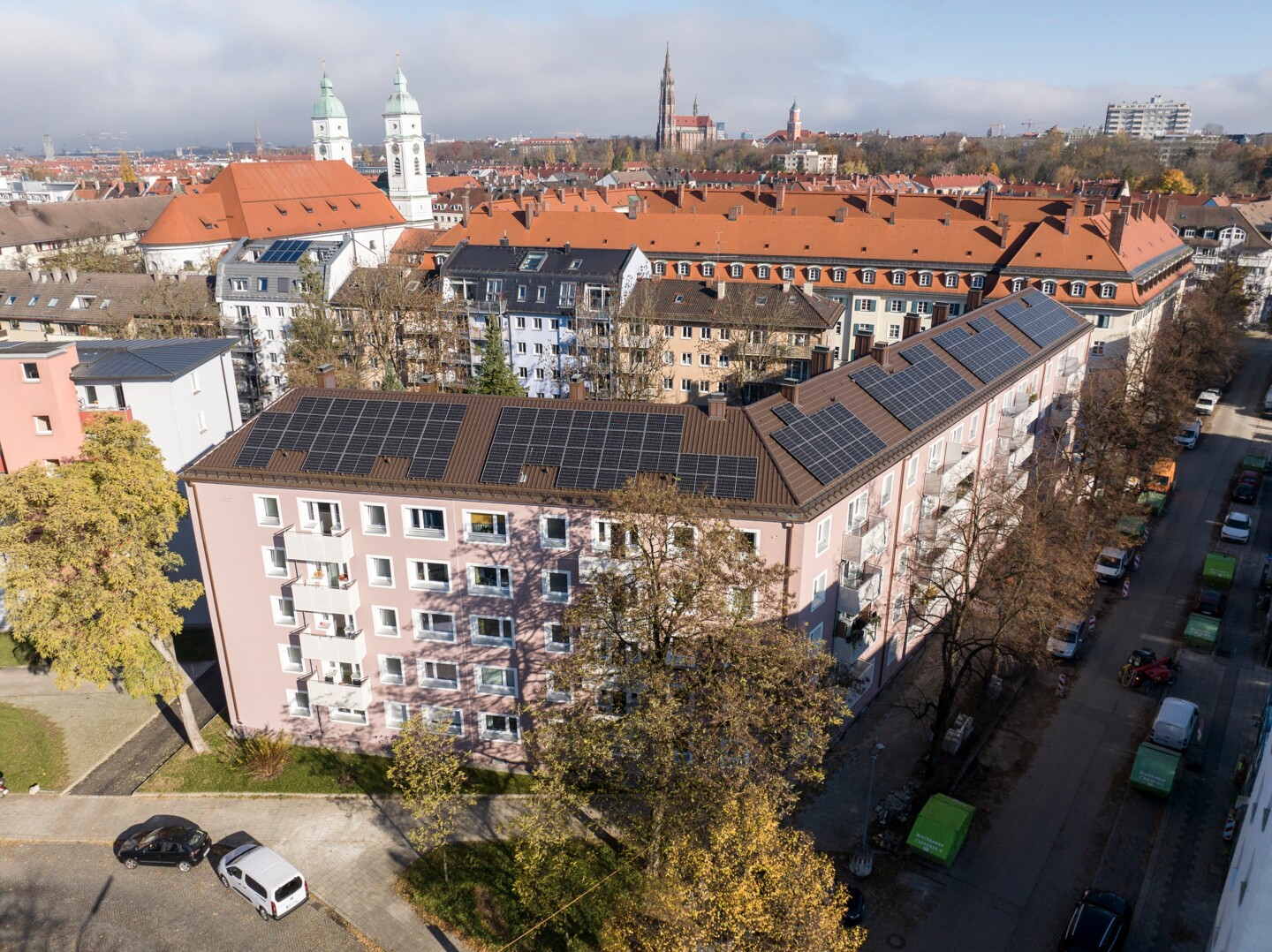 Drohnenaufnahme des Wohnhauses auf dem die Photovoltaikanlage auf dem Dach erkennbar ist. Im Hintergrund die Stadtsilhouette.