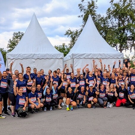 Gruppenbild der Firmenlaufgruppe vor dem Münchner Wohnen Stand im Olympiapark.