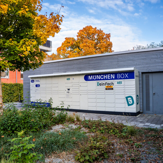 Aufnahme einer München Box Paketstation vor einem Wohnhaus. Viele Fächer unterschiedlicher Größe sind zu sehen.