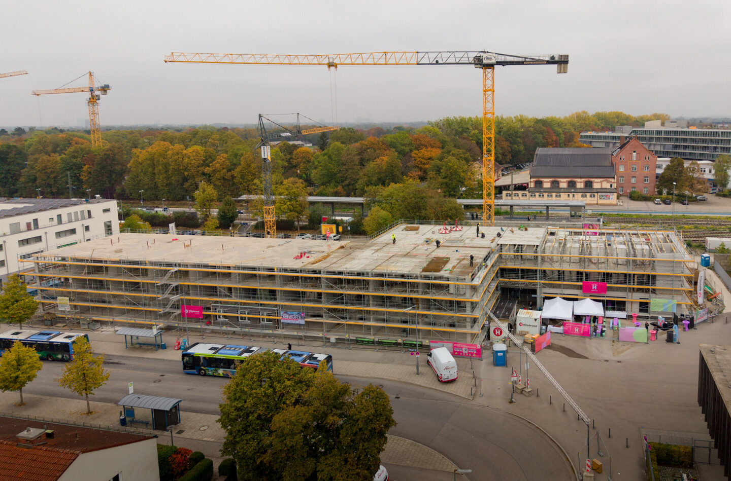Luftbildaufnahme der Baustelle. Das Haus ist mit einem Gerüst verkleidet. Hinter dem Haus steht ein Kran.
