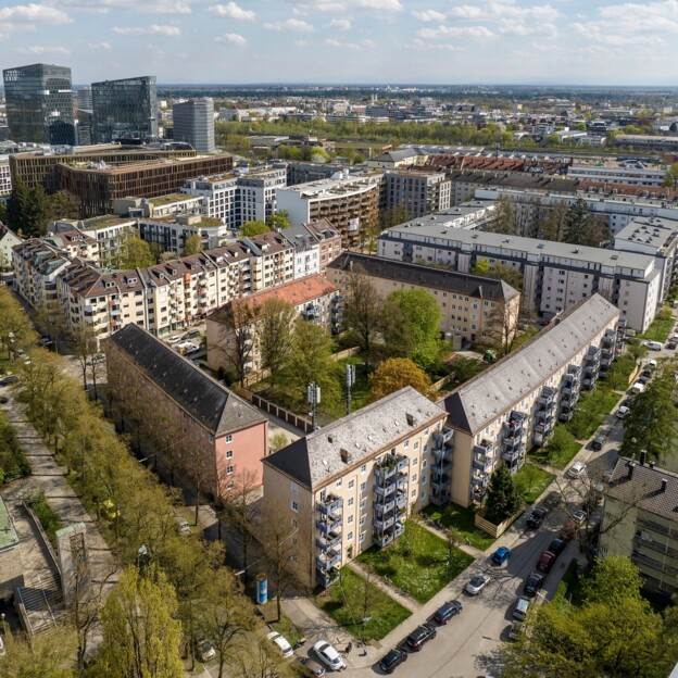 Drohnenaufnahme des Areals in Bogenhausen. Im Vordergrund stehen mehrstöckige Wohnhäuser. Im Hintergrund erkennt man Hochhäuser.